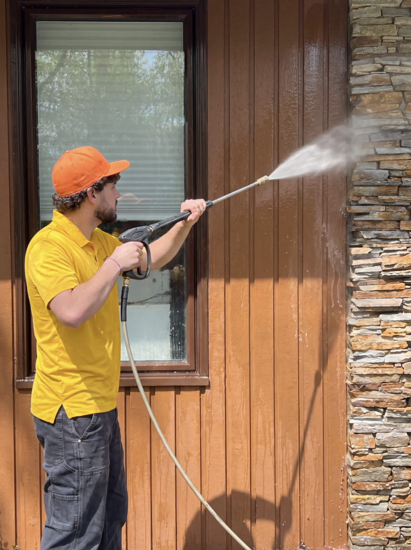Pressure washer cleaning exterior siding of an Edmonton home