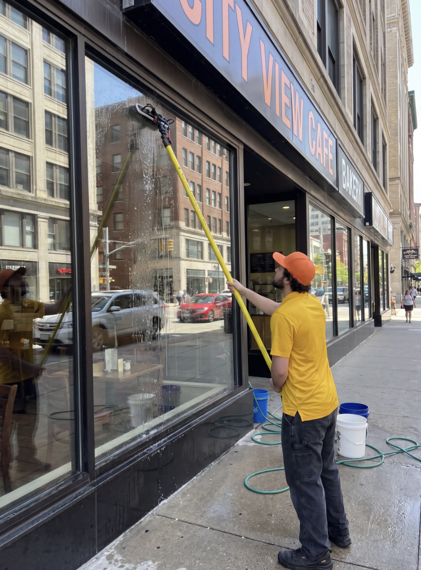 Storefront windows being cleaned in Edmonton with a squeegee